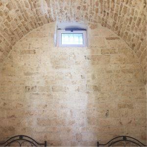 Foto del muro e della volta in pietra nella camera con i due letti singoli