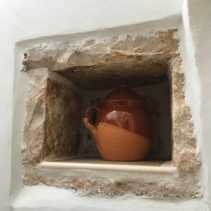Foto di una pignata all'interno di un'apertura quadrangolare nel muro