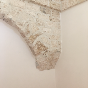 Termine laterale inferiore di un arco in pietra