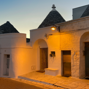 Foto dell'ingresso del trullo illuminato dal vicino lampione