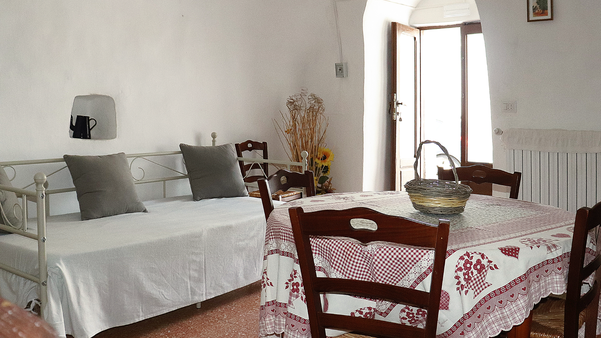 Foto della sala principale con il tavolo da pranzo in primo piano e il divano letto sullo sfondo